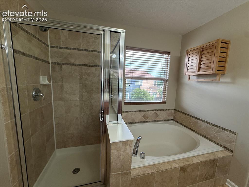 Image 13 of 28: Tiled walk-in shower with clear glass enclosure and chrome fixtures