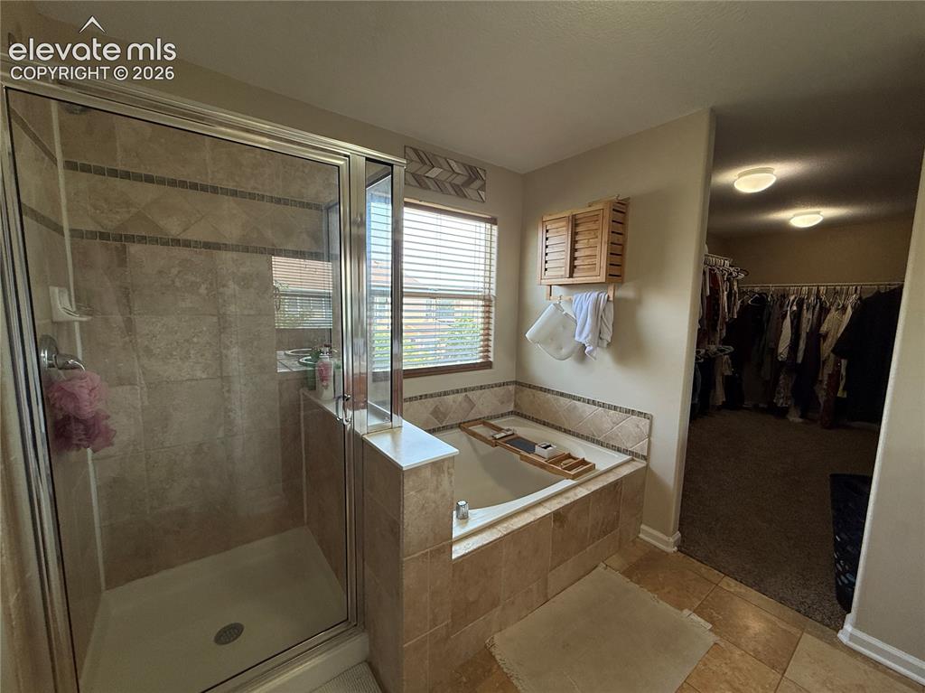 Image 14 of 27: Spa-inspired primary bathroom featuring a walk-in shower with frameless gla