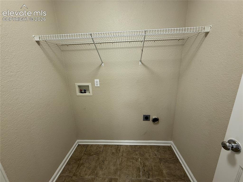 Image 15 of 28: Laundry area featuring a wire shelving unit and tile flooring