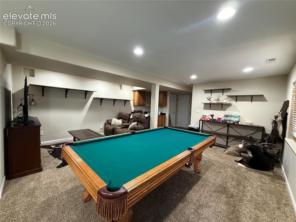 Image 20 of 27: Carpeted recreation area with recessed lighting, built-in shelving, and a w