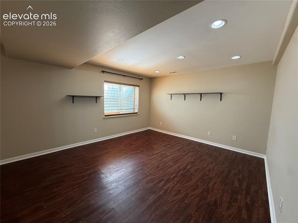 Image 21 of 28: Wood-finish flooring, recessed lighting, and neutral wall tones