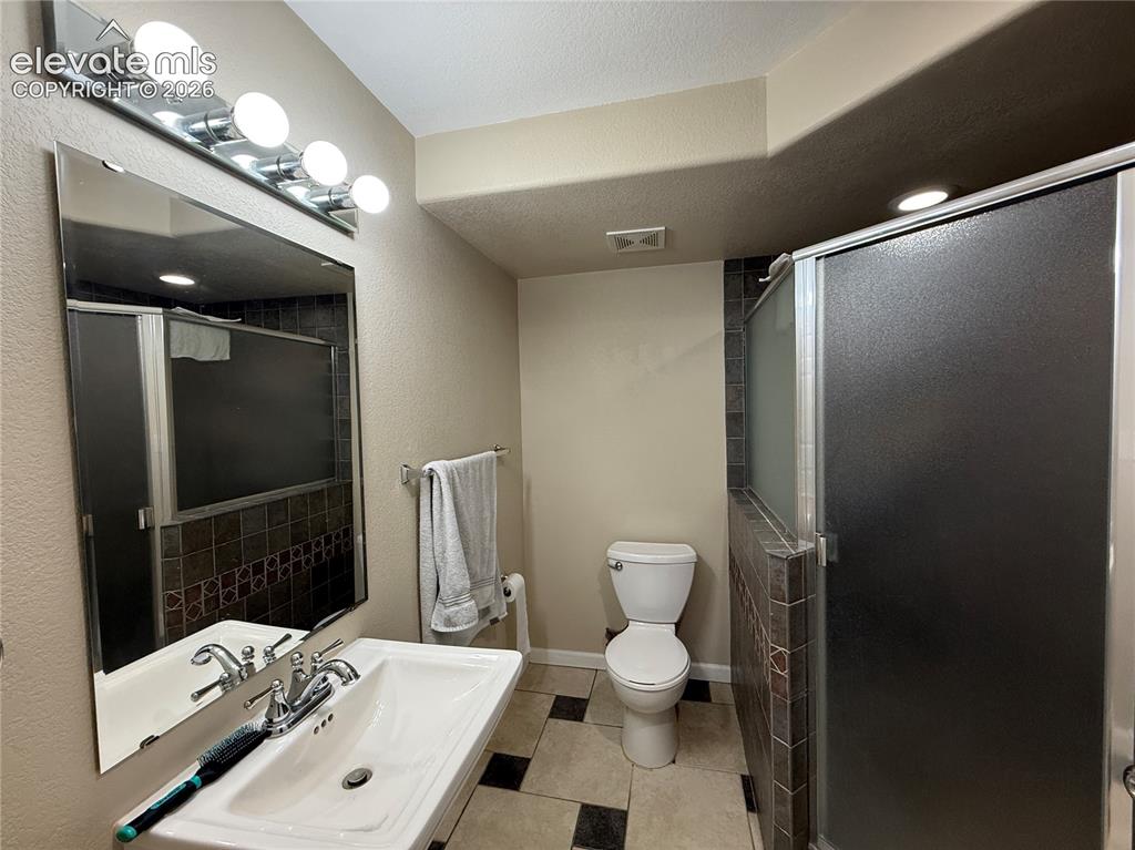 Image 24 of 27: Modern bathroom featuring a vanity with rectangular sink and chrome faucet,