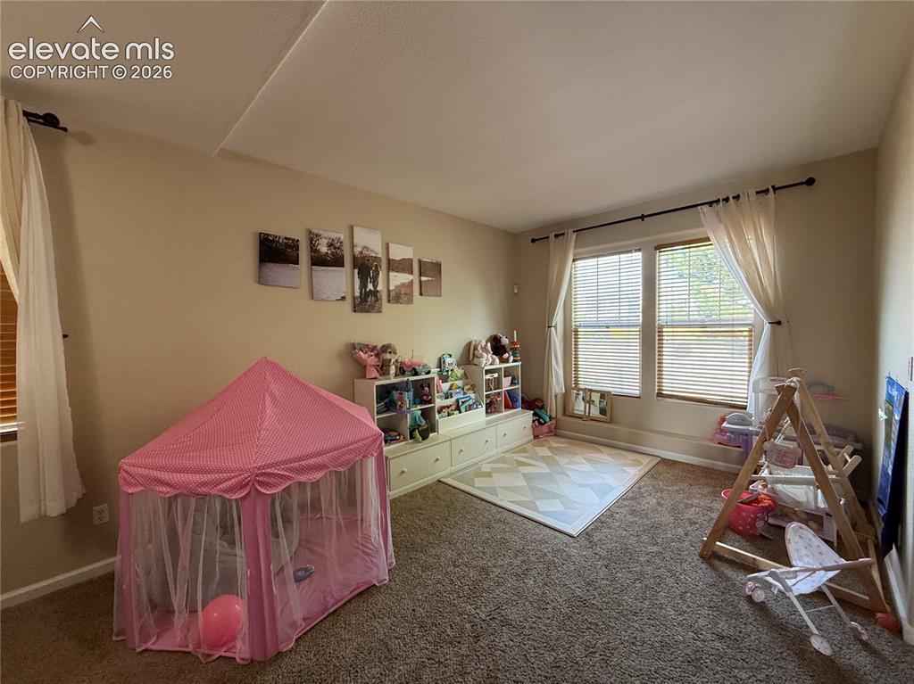 Image 3 of 27: Bright, versatile bedroom featuring neutral wall finishes, abundant natural