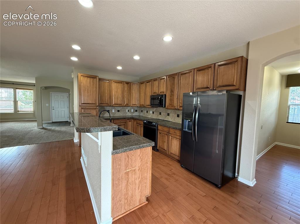 Image 8 of 28: Wood-finish flooring throughout the kitchen and dining area, extensive cabi