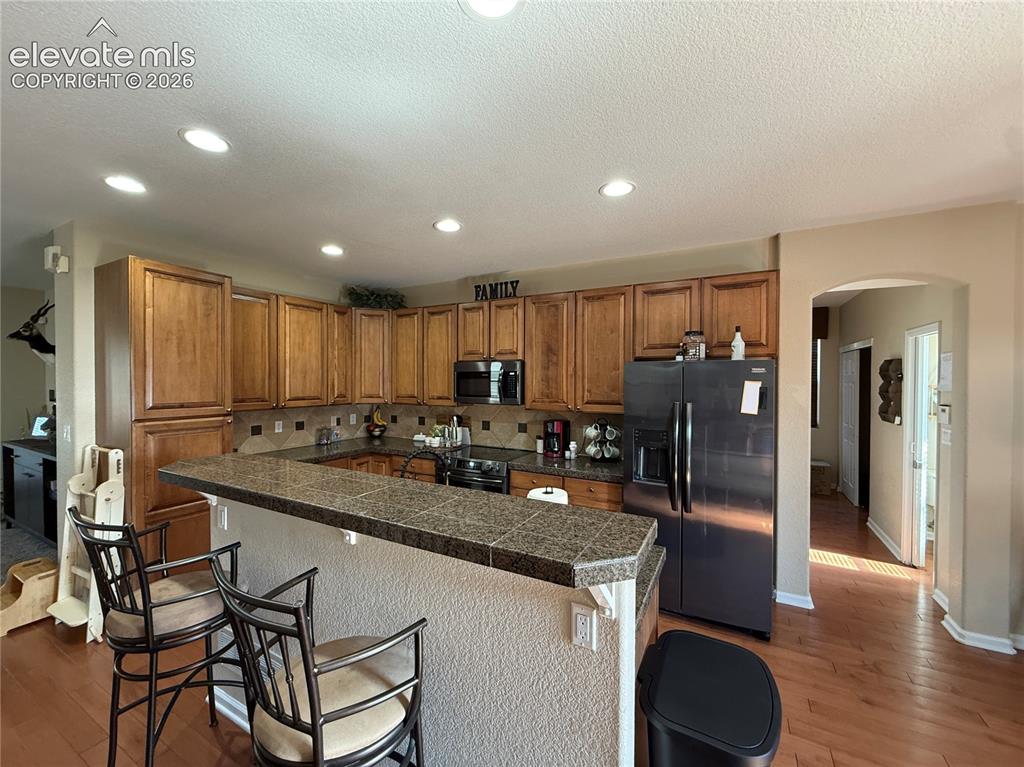 Image 9 of 27: Gourmet kitchen featuring wood cabinetry, granite countertops, stainless st