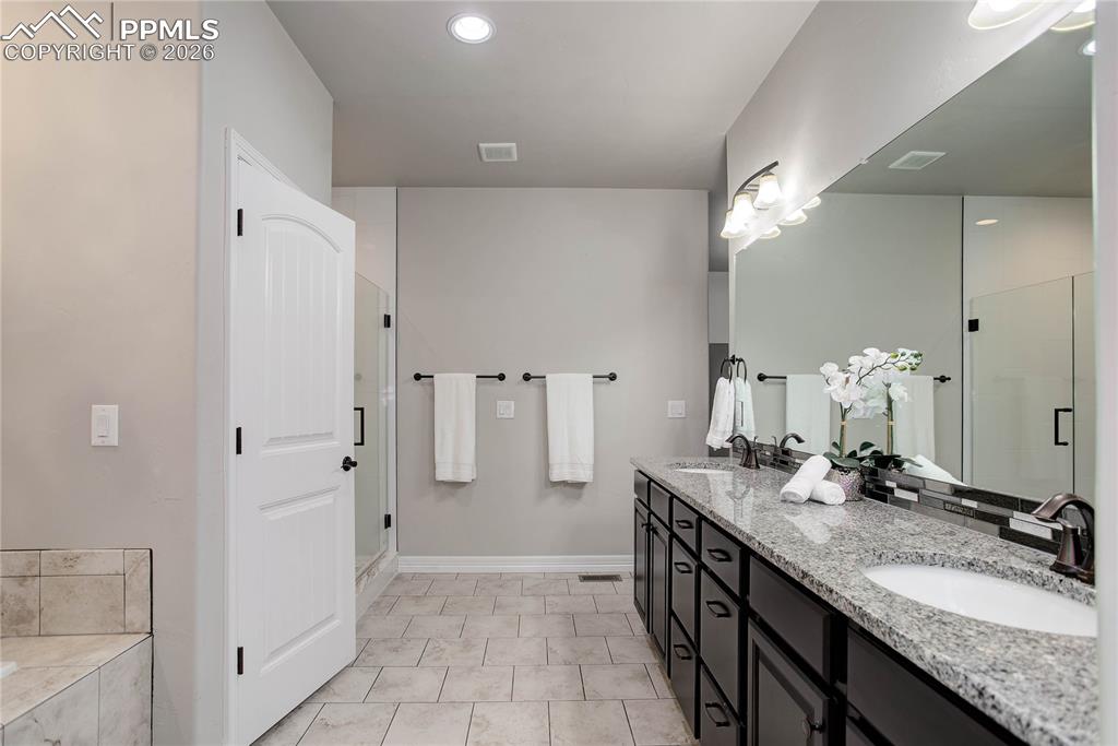 Image 12 of 38: Primary bath w/ dual sink vanity