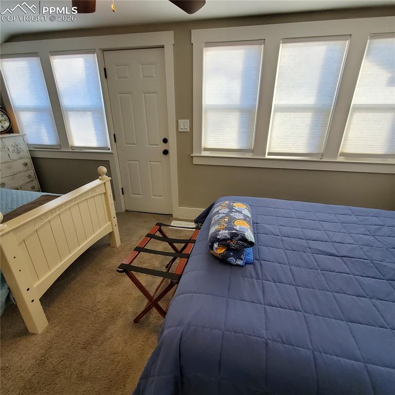 Image 10 of 30: Carpeted bedroom #3 upper level featuring a ceiling fan and lots of windows