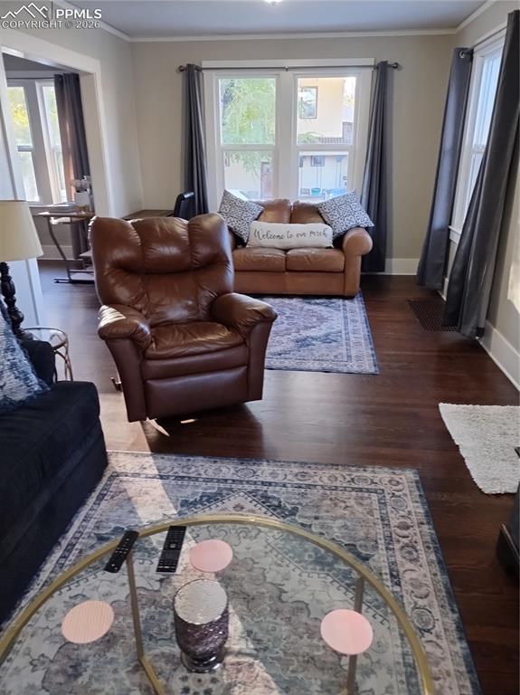 Image 15 of 30: Living area with crown molding, dark wood-style floors, and healthy amount 