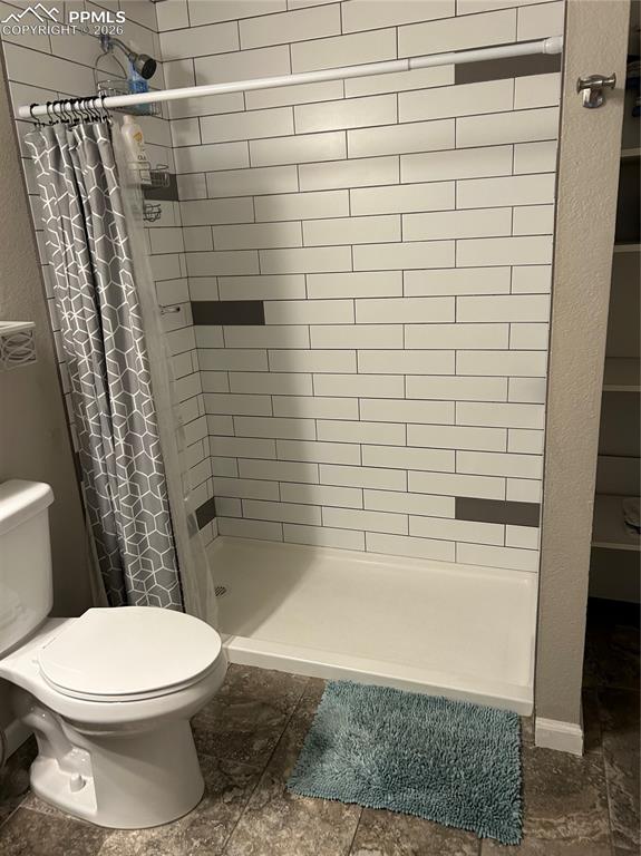 Image 18 of 30: Full bathroom with a shower stall and toilet