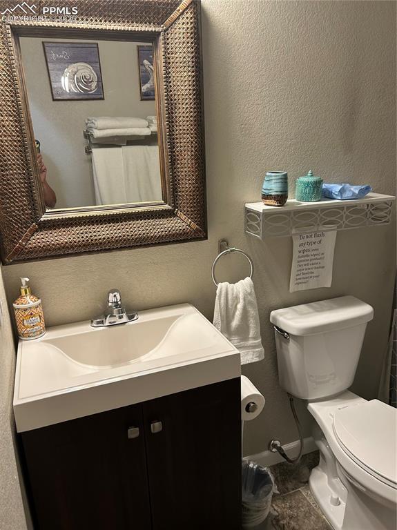 Image 19 of 30: Bathroom featuring a textured wall, vanity, and a shower with shower curtai