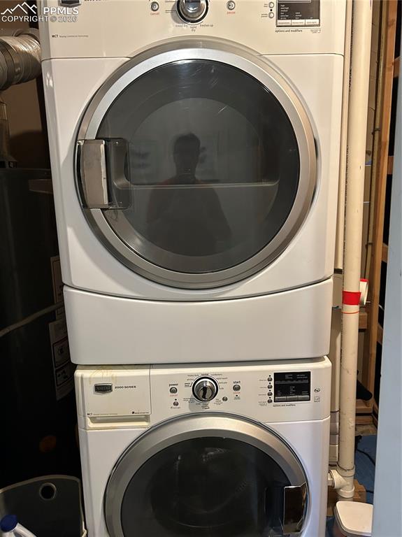 Image 21 of 30: Lower level laundry area featuring stacked washer / dryer