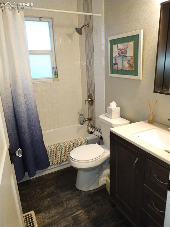 Image 6 of 30: Bathroom featuring vanity, dark wood-style tile
 flooring, a textured wall