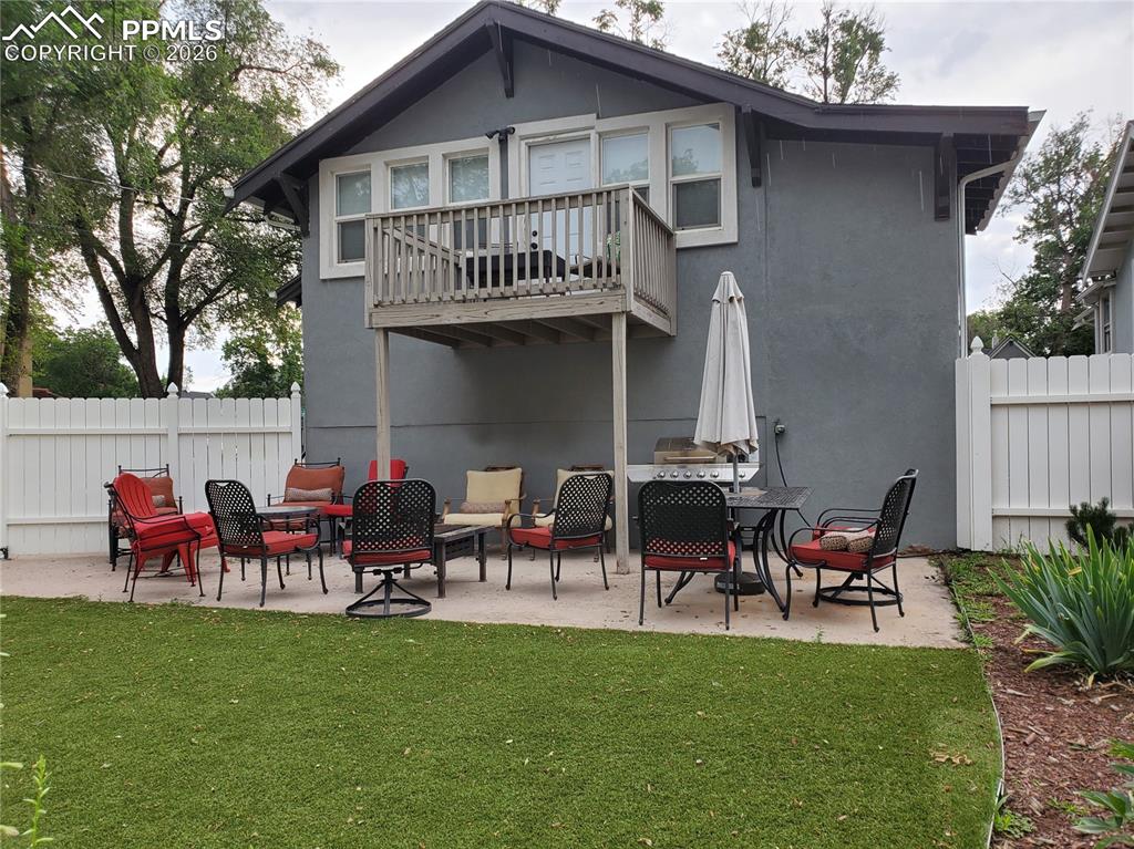 Image 9 of 30: Rear view of property featuring a patio area, stucco siding, a balcony, and