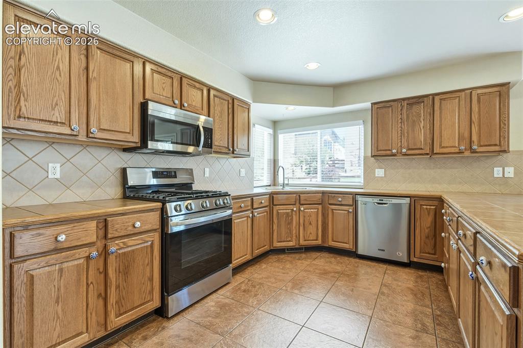Image 11 of 34: Kitchen with loads of cabinetry and stainless appliances
