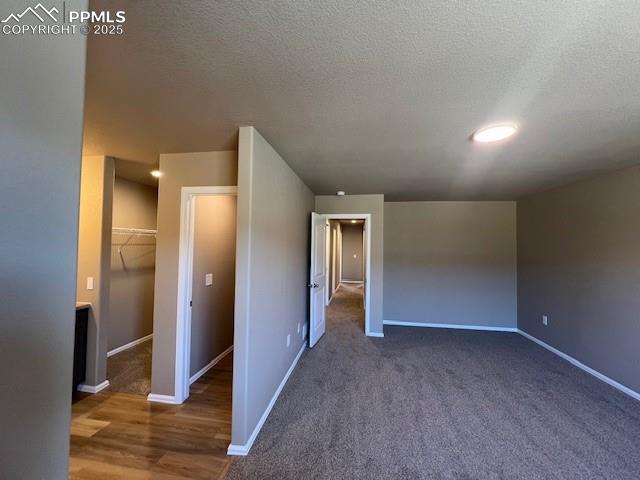 Image 11 of 22: Unfurnished bedroom featuring a spacious closet, a closet, a textured ceili