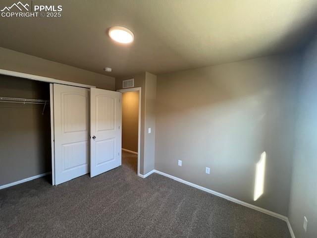 Image 19 of 22: Unfurnished bedroom with a closet and dark carpet
