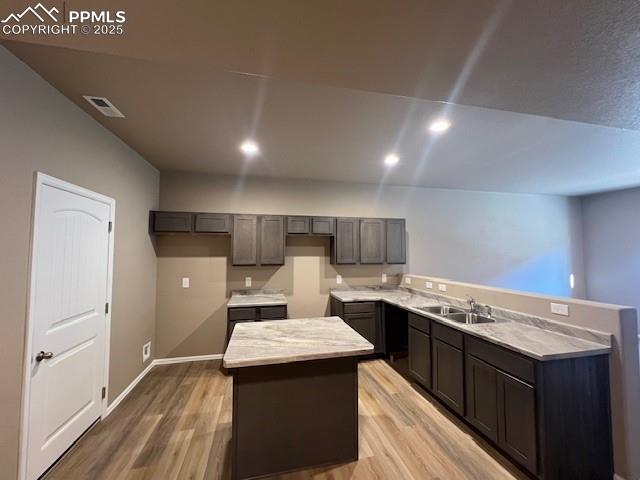 Image 6 of 22: Kitchen featuring a kitchen island, light hardwood / wood-style floors, and