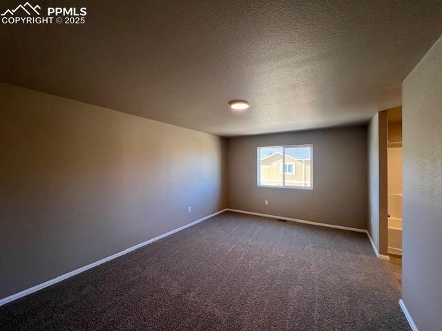 Image 8 of 22: Spare room with carpet floors and a textured ceiling