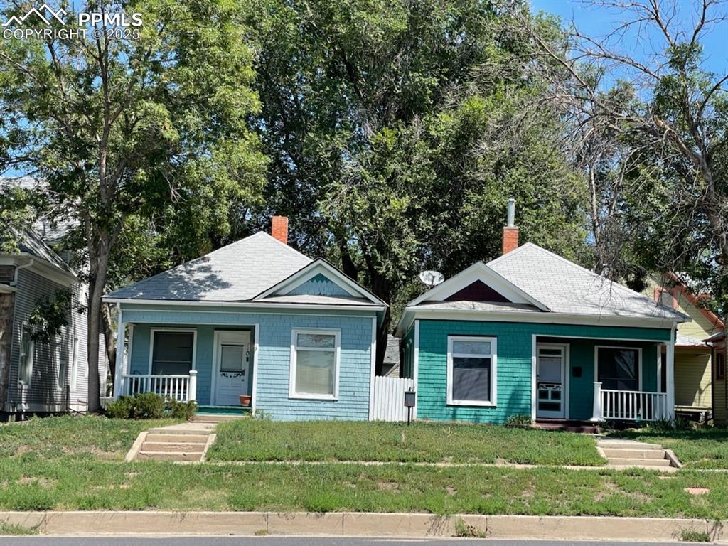 Caption: Bungalow-style house featuring covered porch, a front yard, a chimney, and roof with shingles