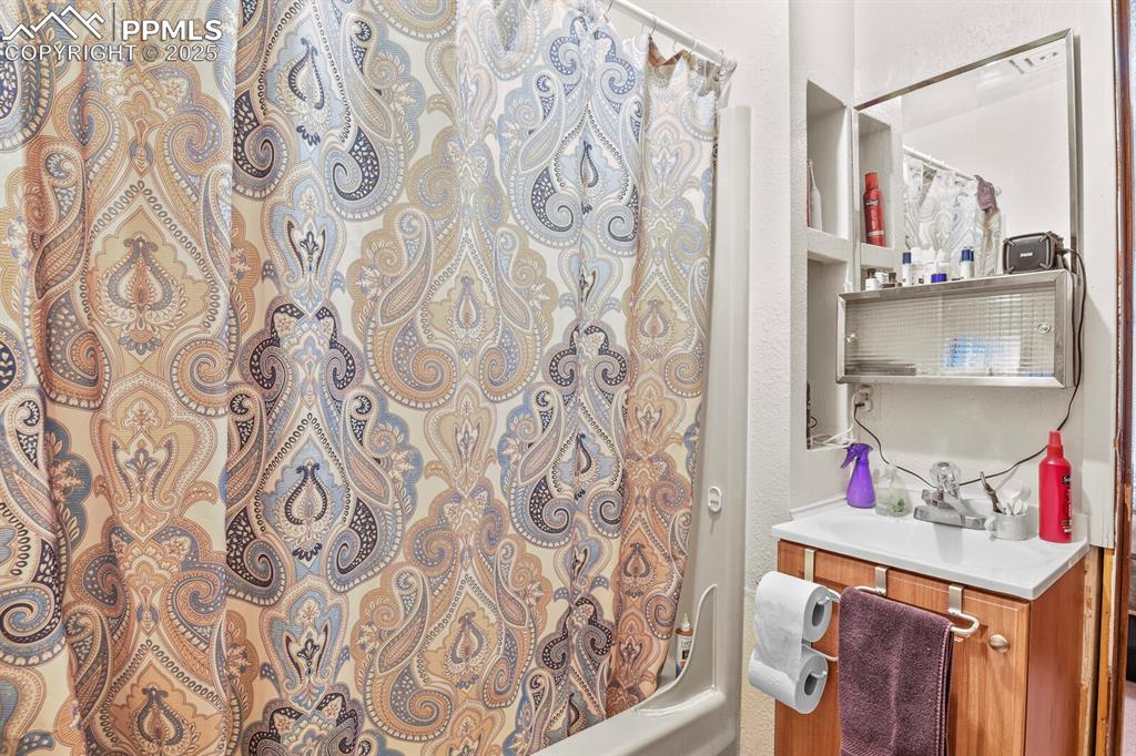 Image 10 of 30: Bathroom featuring vanity, shower / bath combination with curtain, and a te