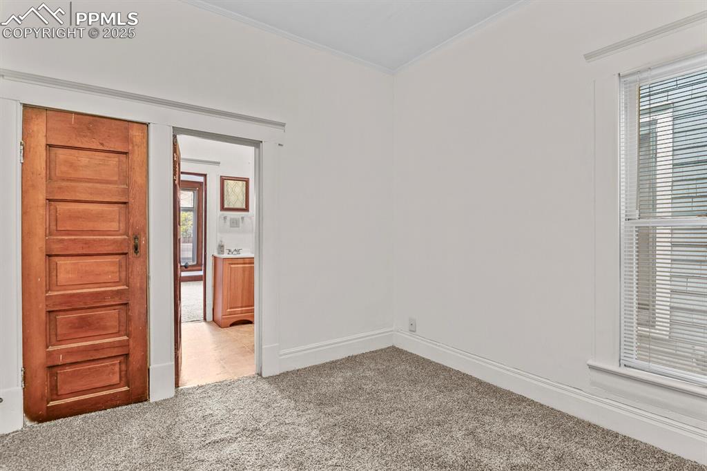 Image 16 of 30: Spare room with light carpet, crown molding, and healthy amount of natural