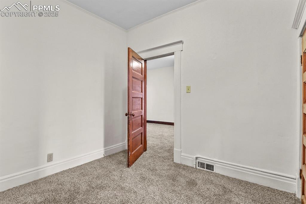 Image 17 of 30: Unfurnished room featuring light carpet and ornamental molding
