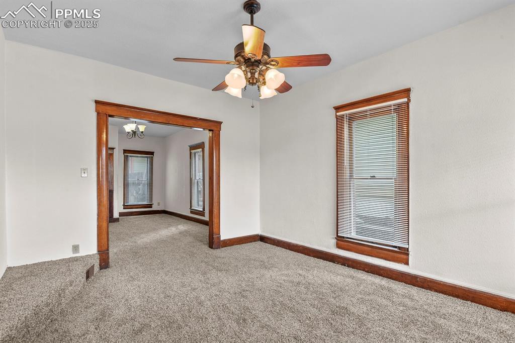 Image 20 of 30: Spare room with carpet floors, a chandelier, and a ceiling fan