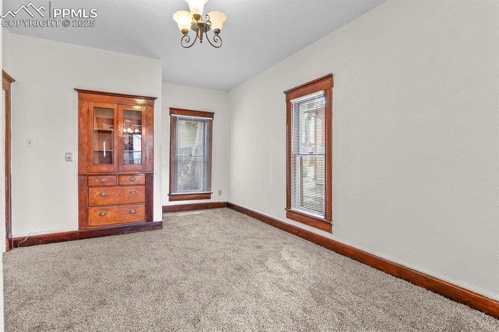 Image 21 of 30: Empty room with a chandelier, plenty of natural light, and carpet