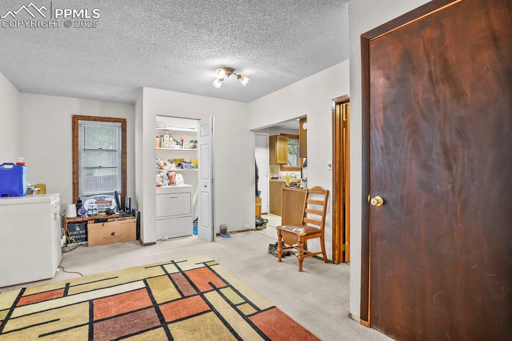 Image 4 of 30: Foyer entrance featuring light carpet, washer / dryer, and a textured ceili