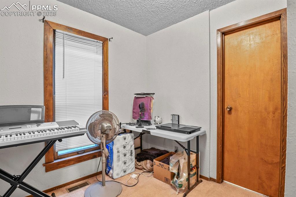 Image 5 of 30: Carpeted home office featuring a textured ceiling and a textured wall