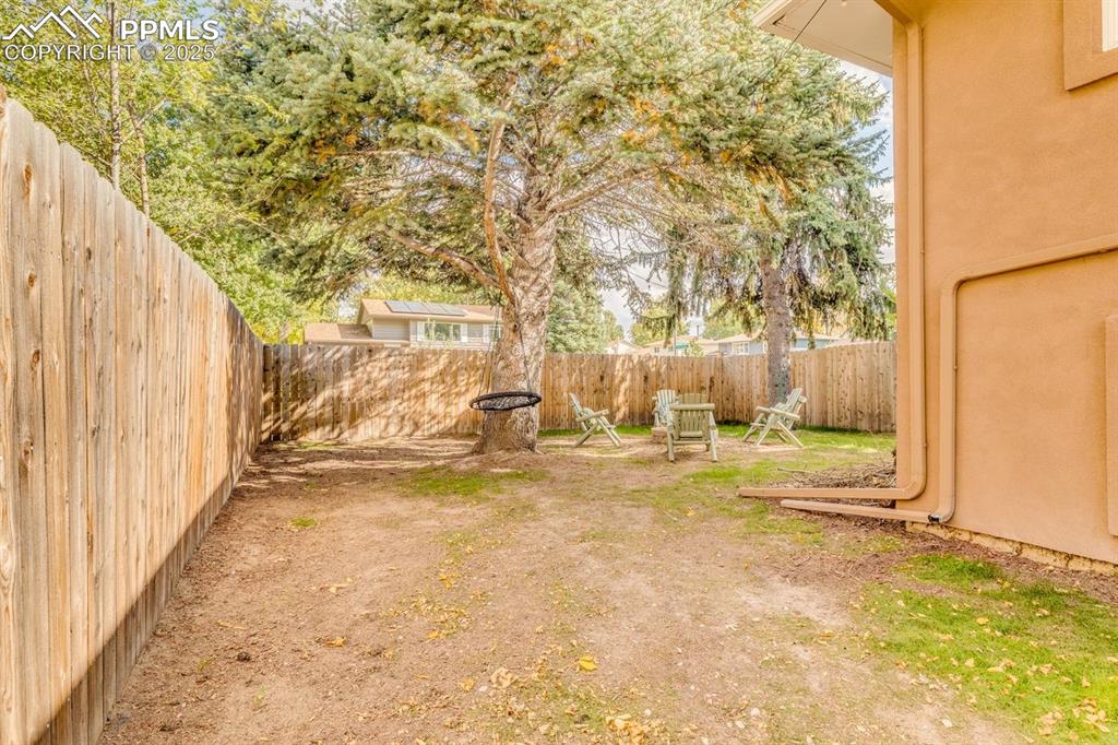 Image 14 of 47: View of fenced backyard with fire pit.