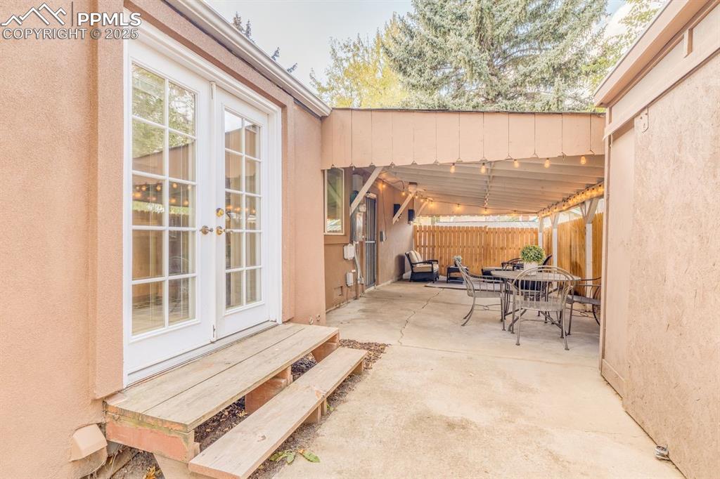 Image 20 of 47: French doors opening to the patio / terrace featuring outdoor dining area a