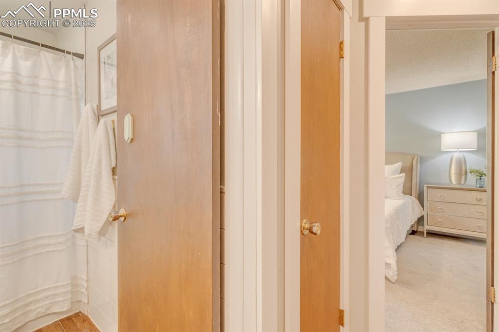 Image 31 of 47: Bathroom and primary bedroom from the hallway.