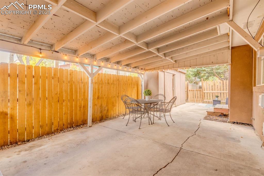 Image 39 of 47: Fenced backyard with outdoor dining area and a patio area