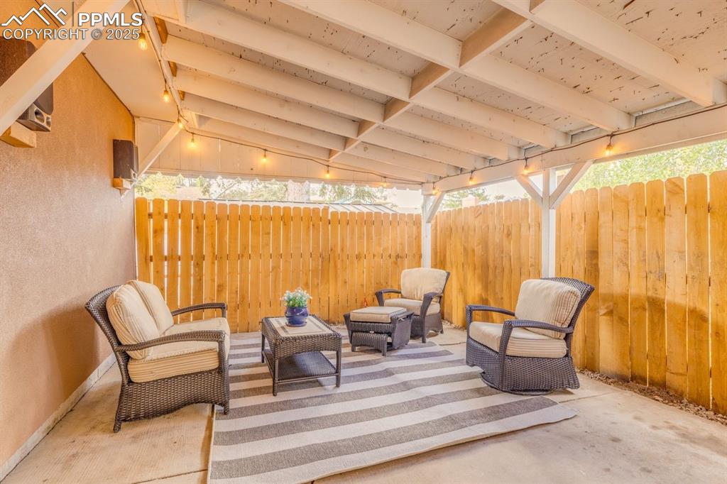 Image 41 of 47: Fenced backyard with a patio and outdoor lounge area
