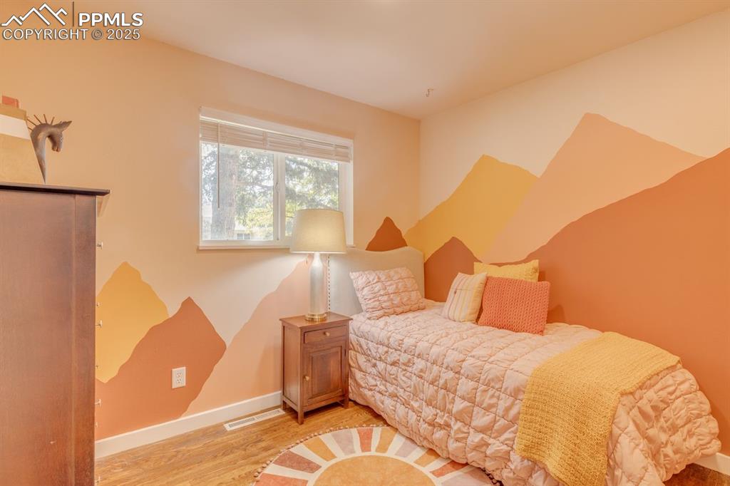 Image 6 of 47: Bedroom with wood floors, painted wall.