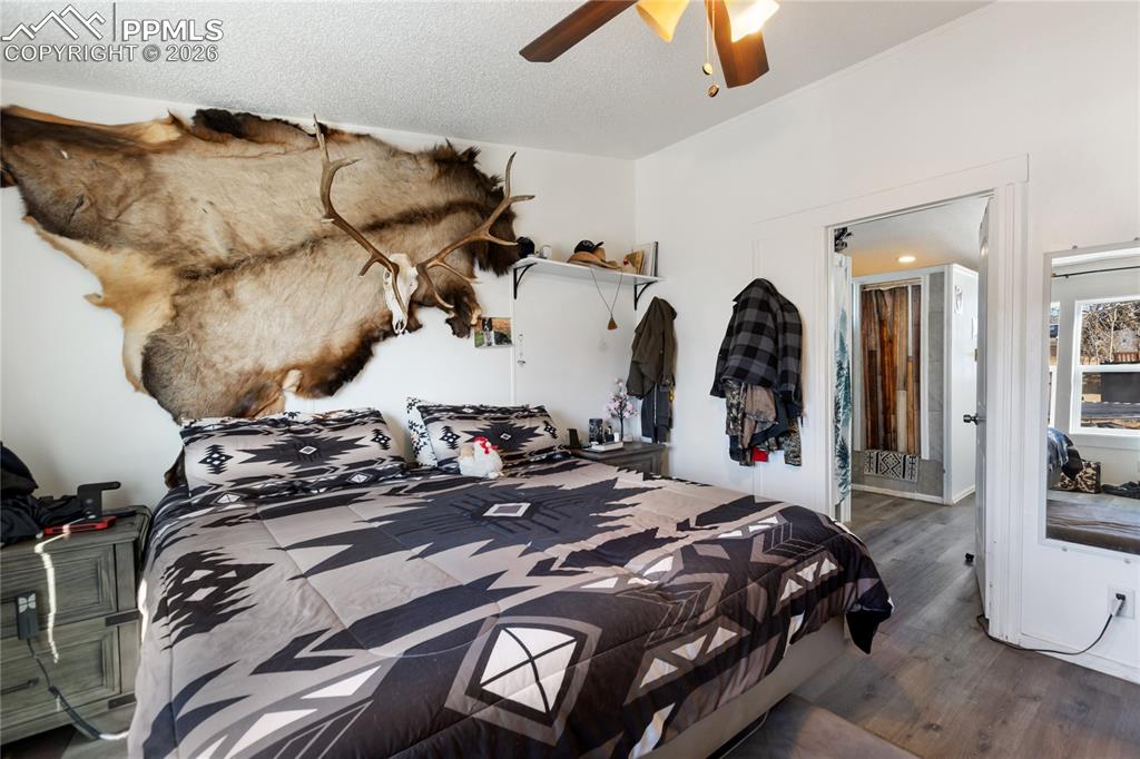 Image 14 of 27: The main bedroom has wood flooring, and a ceiling fan!