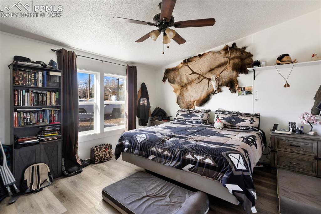 Image 15 of 27: The main bedroom with wood finished floors, and a ceiling fan!