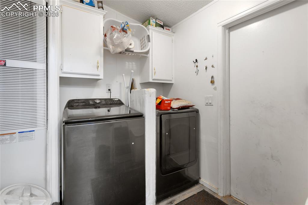 Image 16 of 27: The laundry room has a washer and dryer, plus cabinet space!