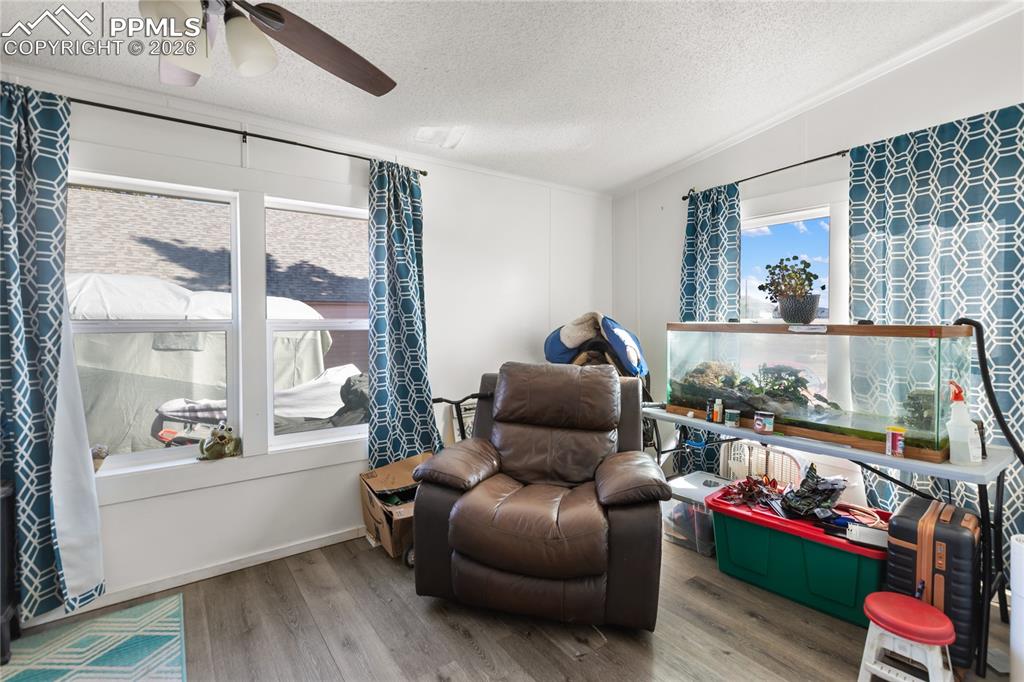 Image 17 of 27: A bedroom with wood floors and a ceiling fan!