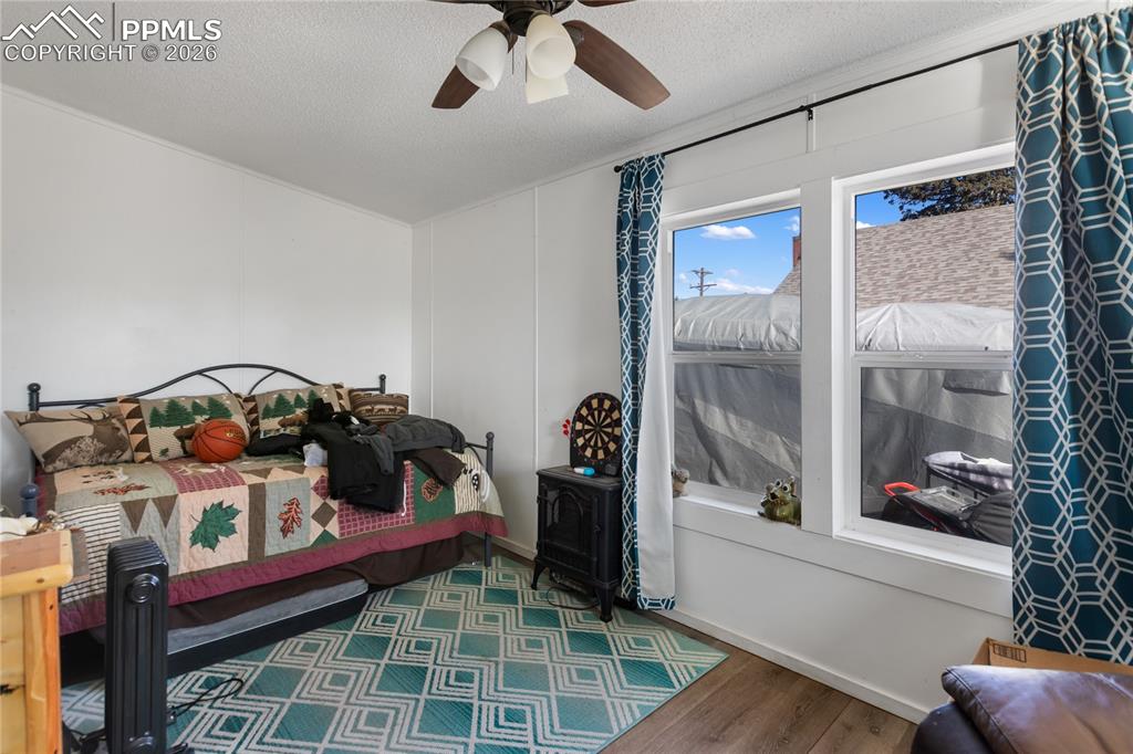 Image 18 of 27: A bedroom with wood floors, and a ceiling fan!