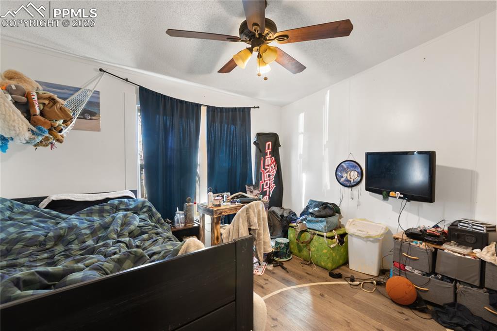Image 20 of 27: A bedroom featuring wood floors and a ceiling fan!