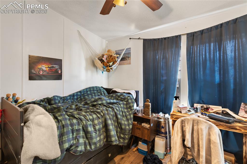 Image 21 of 27: A bedroom with wood floors and a ceiling fan!