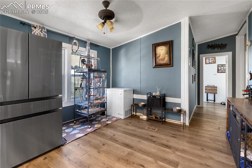 Image 7 of 27: The dining space with wood floors, ceiling fan, and ornamental molding!