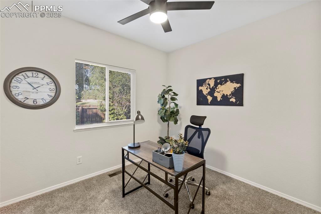 Image 19 of 39: Quiet and bright, the main-level office features hardwood flooring and make
