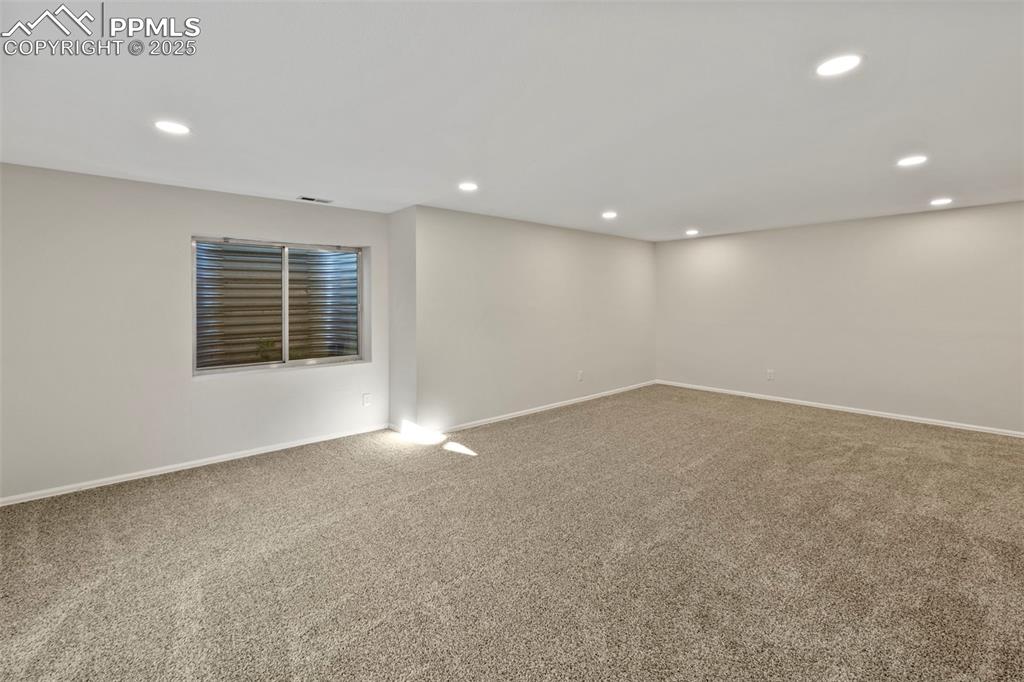 Image 23 of 39: The finished basement opens into a large family room, perfect for movie nig
