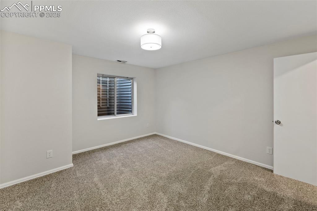Image 27 of 39: Downstairs, two additional bedrooms offer plush carpet, walk-in closets, an