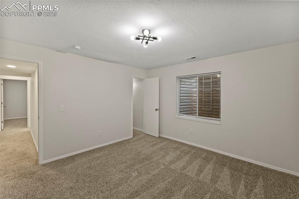 Image 30 of 39: Perfect for guests, teens, or home gym setups, the basement bedrooms feel p