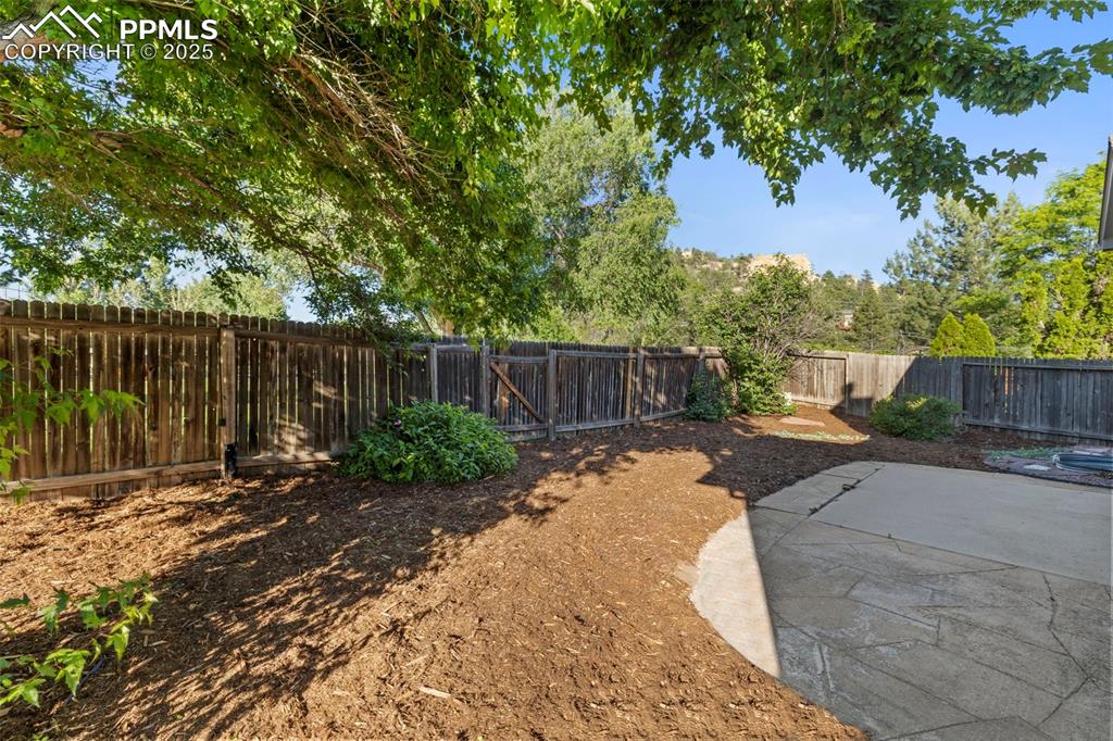 Image 34 of 39: Out back, a fenced yard with a patio and private gate creates the perfect c