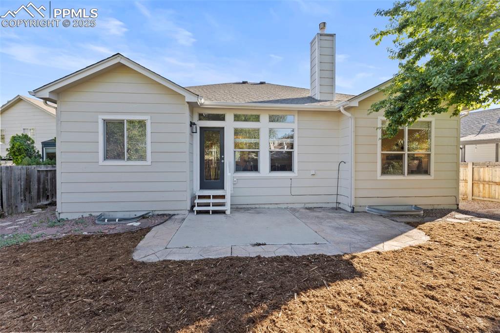 Image 36 of 39: Out back, a fenced yard with a patio and private gate creates the perfect c